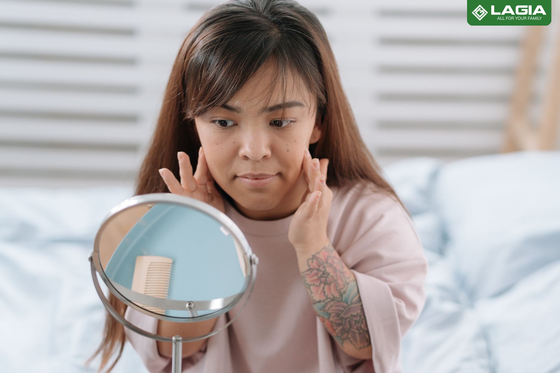 Phụ nữ soi gương kiểm tra độ đàn hồi của da mặt