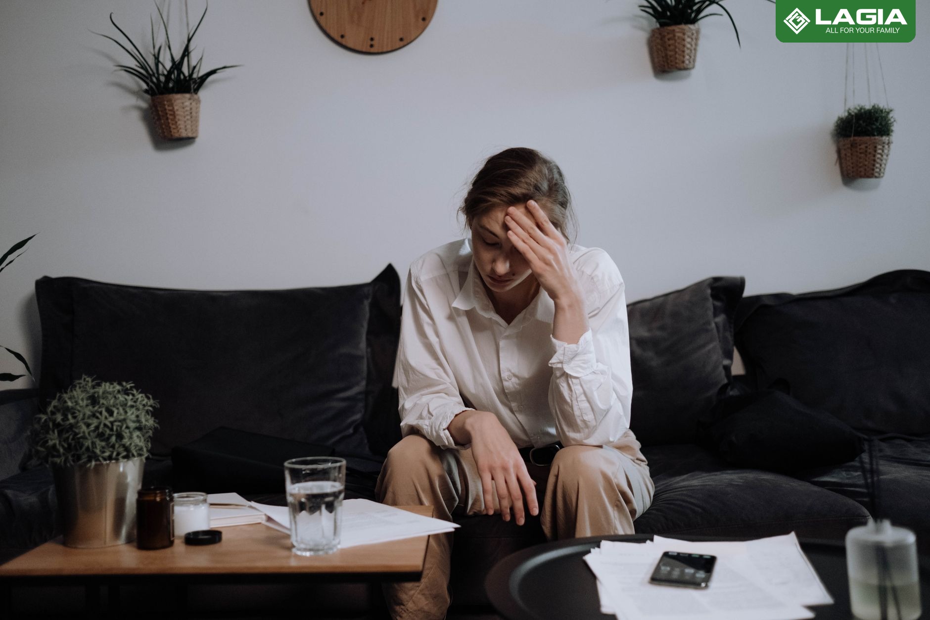 Người phụ nữ ngồi mệt mỏi trên ghế sofa vì thiếu máu kéo dài không cải thiện